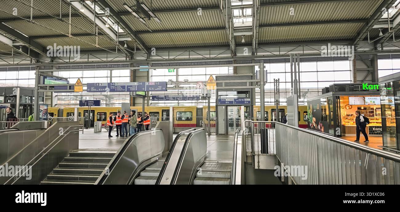 Belin, Germany - May 19, 2025: Modern train station interior features escalators and passengers moving through the space. - Smartphone Captured Stock Image