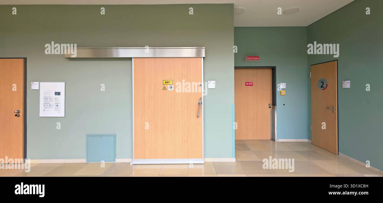 Berlin, Germany - June 16, 2025: Modern hospital corridor features wooden doors and green walls creating a calming atmosphere. - Smartphone Captured Stock Image