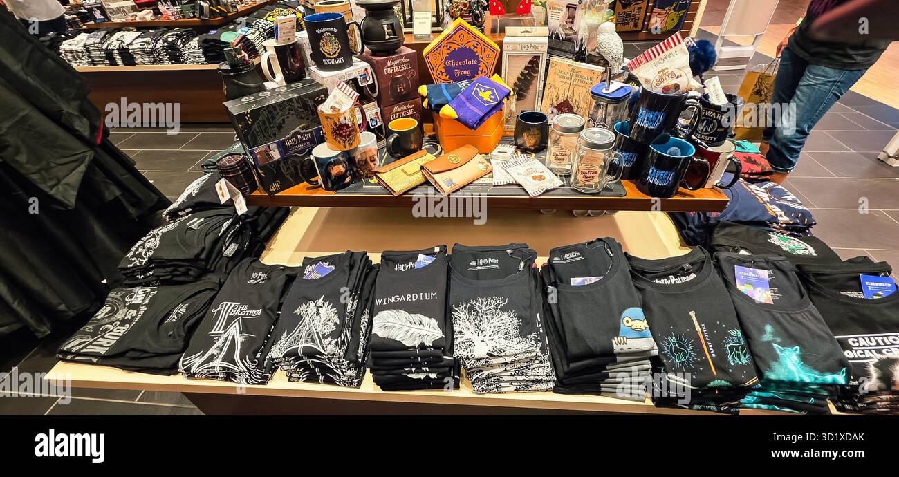 Berlin, Germany - June 13, 2025: Merchandise display shows graphic t-shirts and various collectibles in retail store. - Smartphone Captured Stock Image