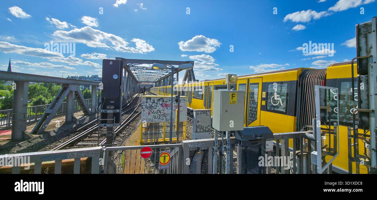 Berlin, Germany - July 04, 2025: Yellow train is crossing a bridge with blue sky and clouds in the background. - Smartphone Captured Stock Image Berlin, Germany - July 04, 2025: Yellow train is crossing a bridge with blue sky and clouds in the background. - Smartphone Captured Stock Image