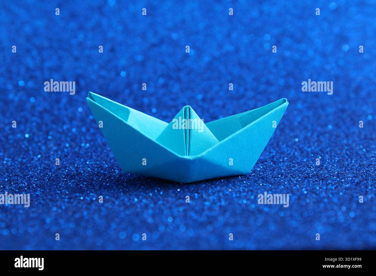 Paper boat on a bright blue background Stock Photo