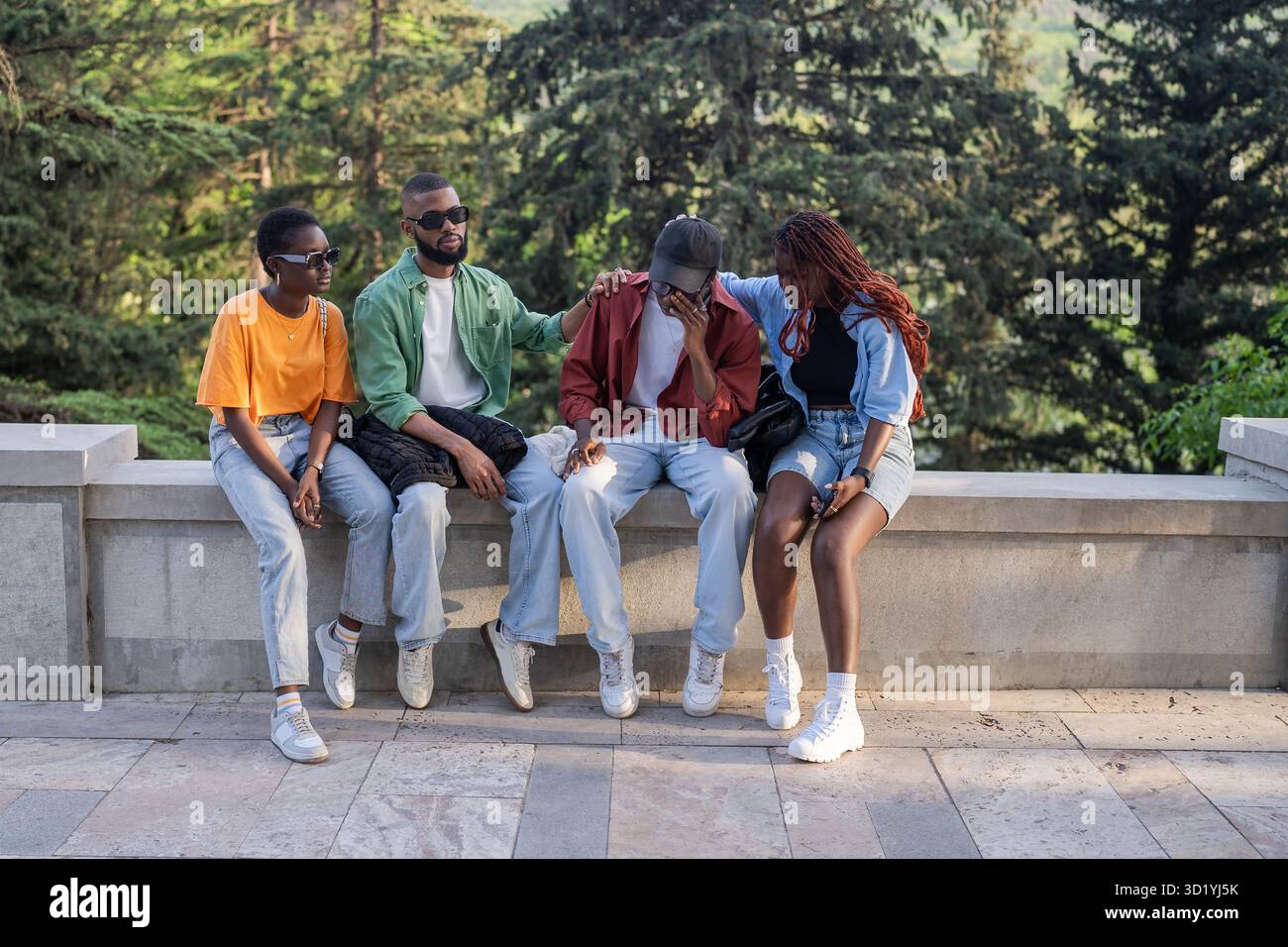 Stressed despaired African student almost cry due to failed exam or broke up, friends consoling peer Stock Photo