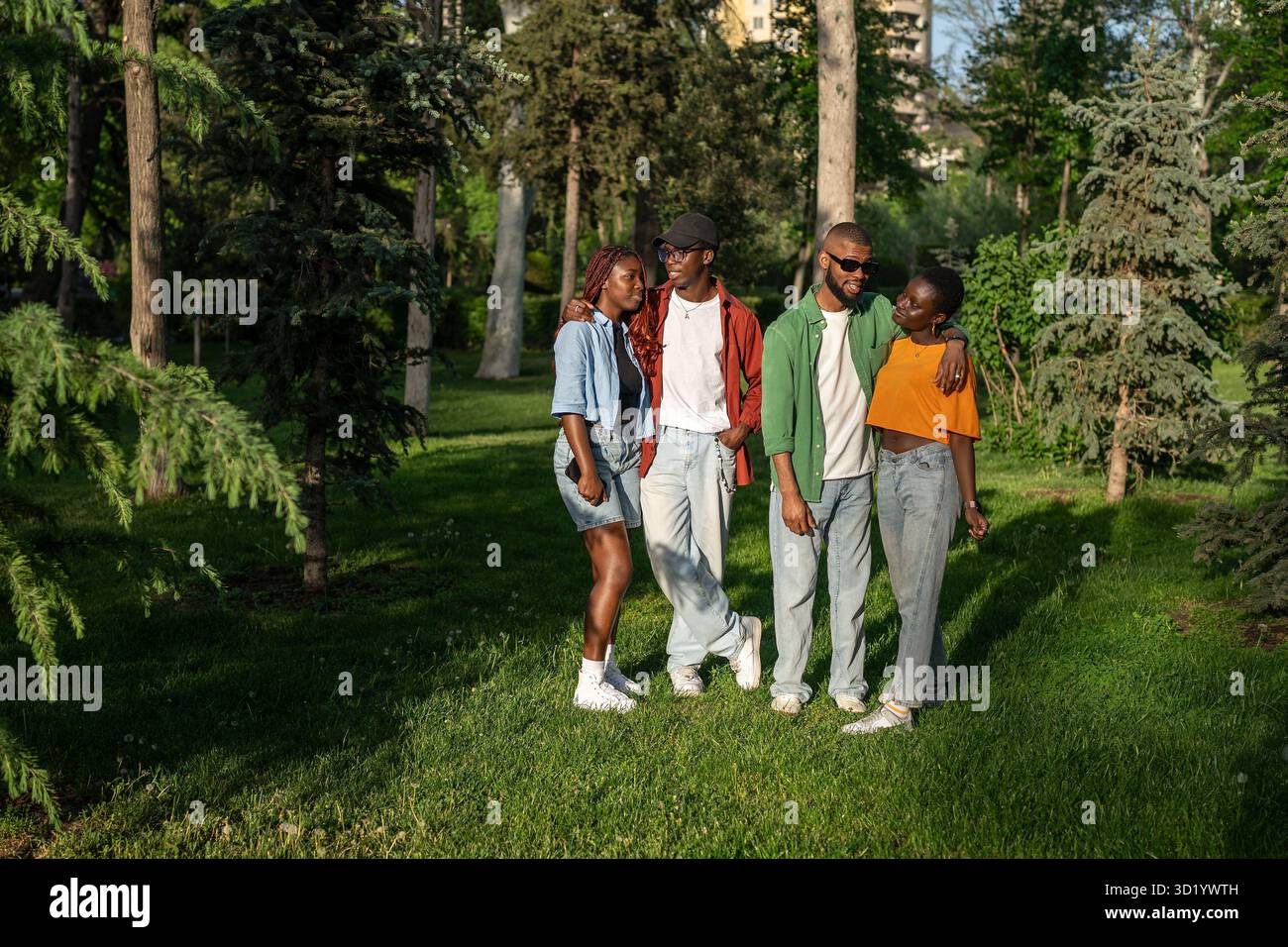 Young multiracial group of friends travel together, stand and posing for camera in park woods Stock Photo