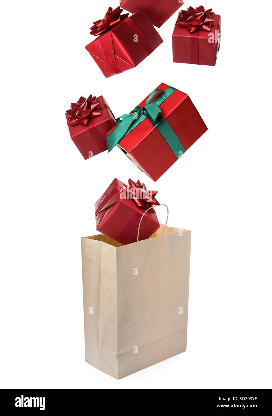 Many gift boxes falling into paper bag on white background Stock Photo