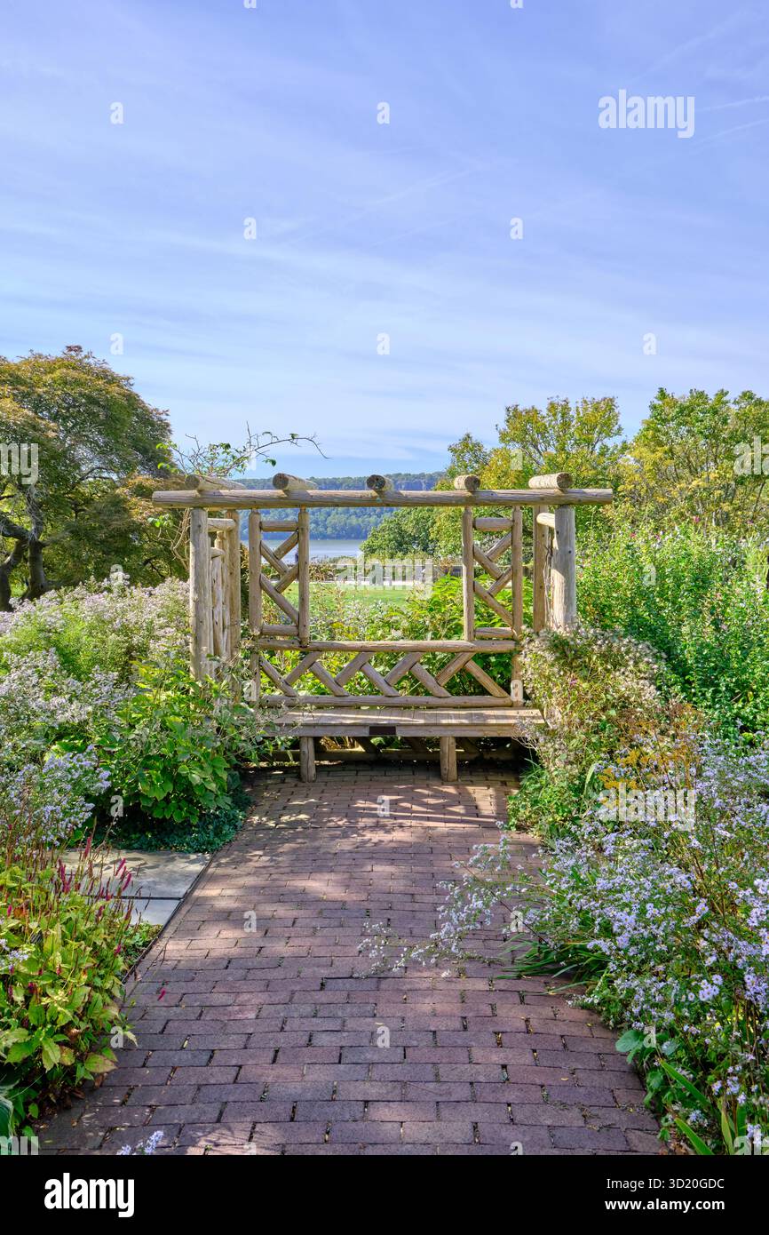 Scenic garden pathway leading to a rustic wooden arbor constructed from ...
