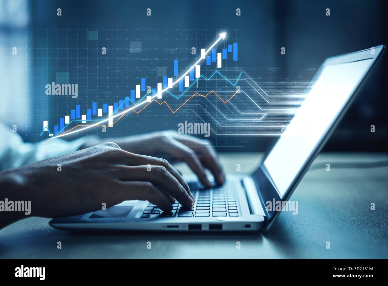 A close-up view of hands typing on a laptop featuring financial graphs and data visualizations representing growth and analysis in a modern workspace. Stock Photo