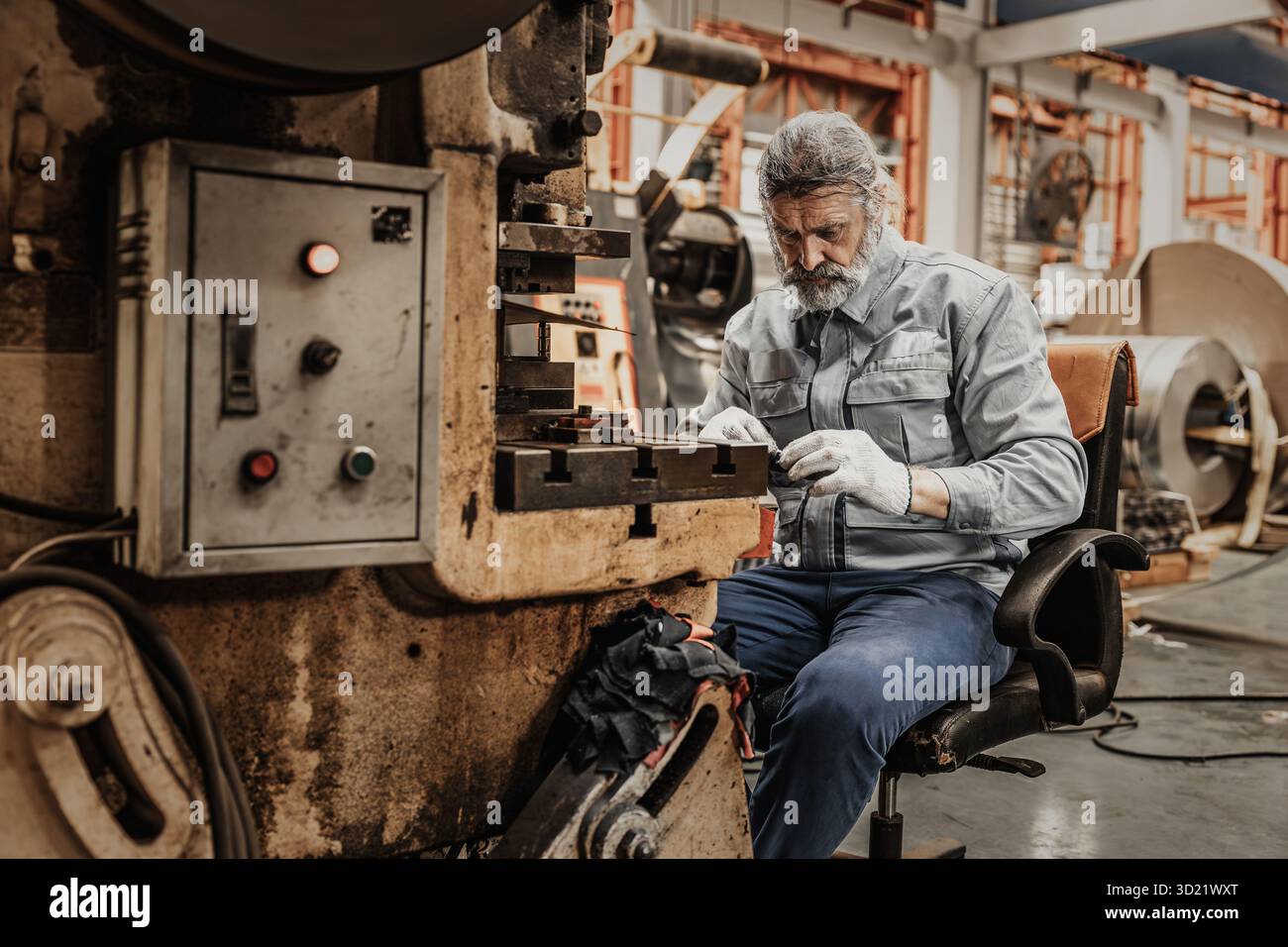 Elderly man hard working, senior old man skill labor master hand make metal work piece in heavy industry Stock Photo