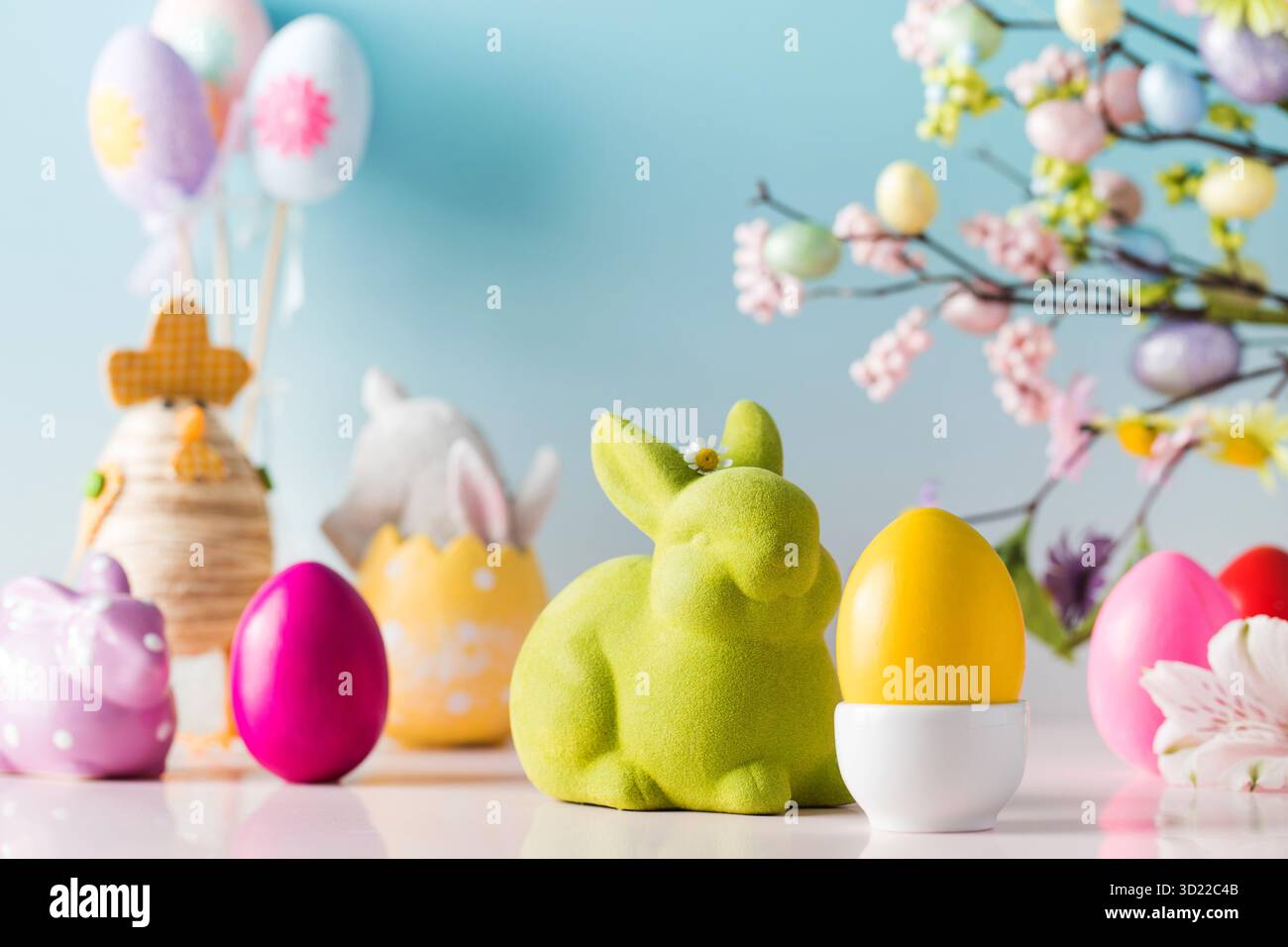 Festive Easter composition with Easter eggs and rabbits on a blue background. Stock Photo