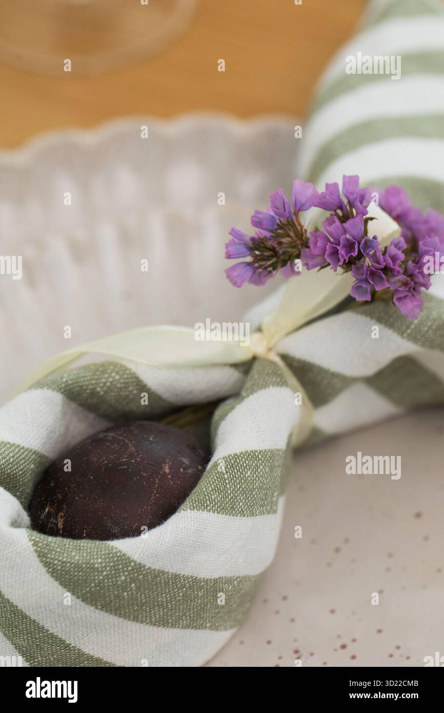 Easter egg wrapped in linen napkin in the shape of bunny with ears. Happy Easter Stock Photo