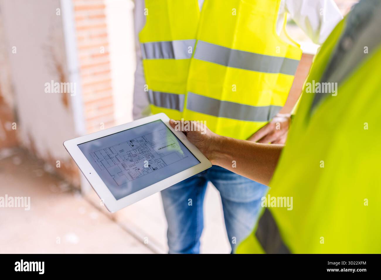 Engineers using digital tablet showing blueprint at construction site Stock Photo