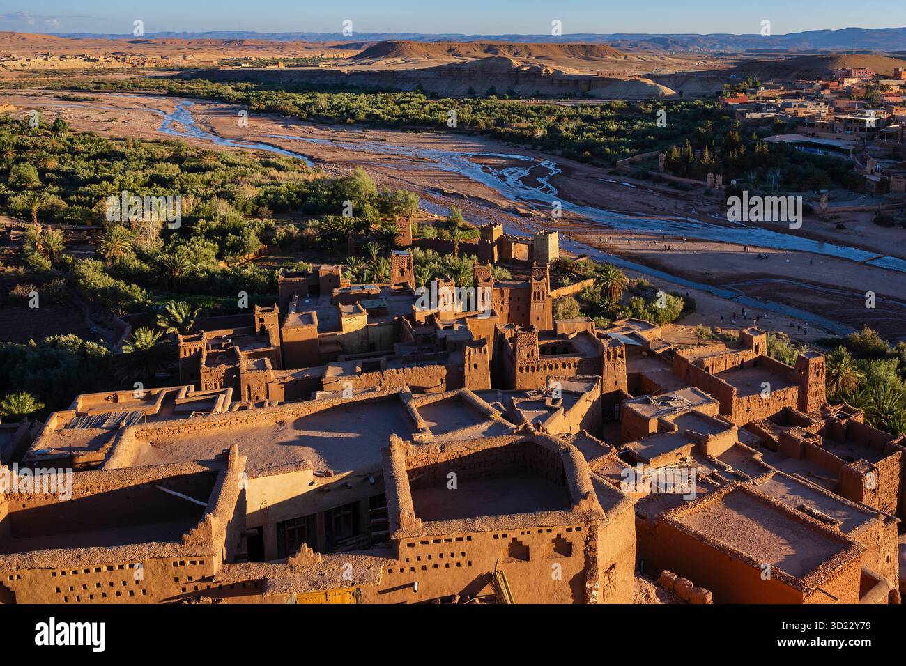 Ancient desert city skyline with river and mountains in the background ...