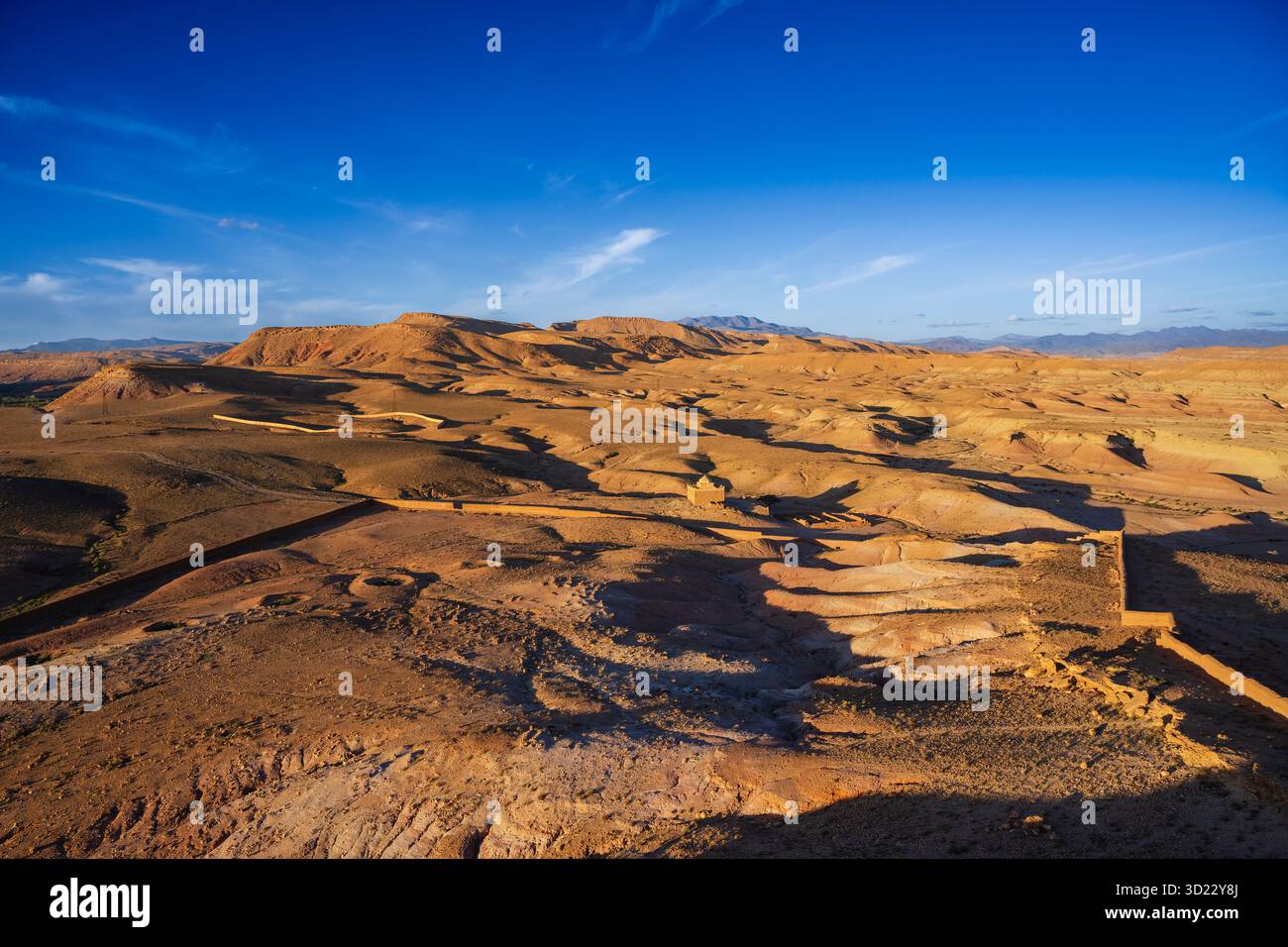 Expansive desert landscape with rolling hills under a bright blue sky ...