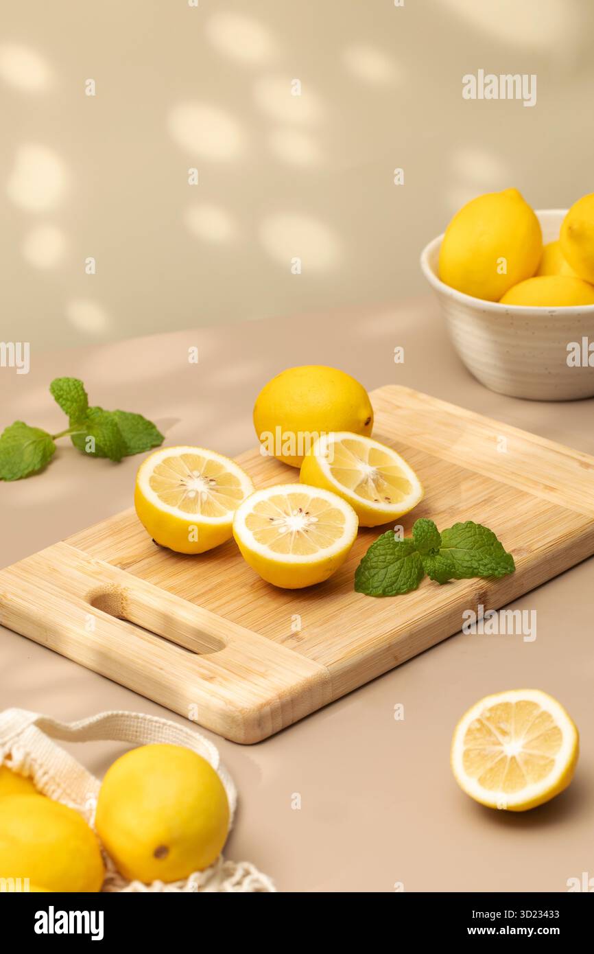 Whole and halves of yellow lemons on a wooden board. Juicy ripe lemons. Stock Photo