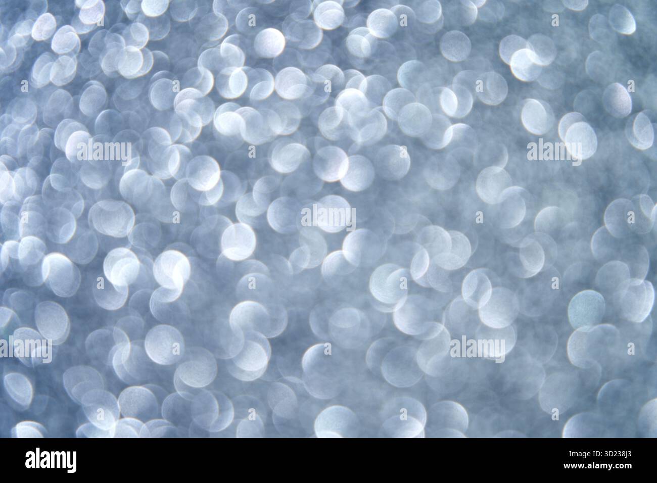 Abstract silver bokeh background with defocused circular light patterns creating Stock Photo