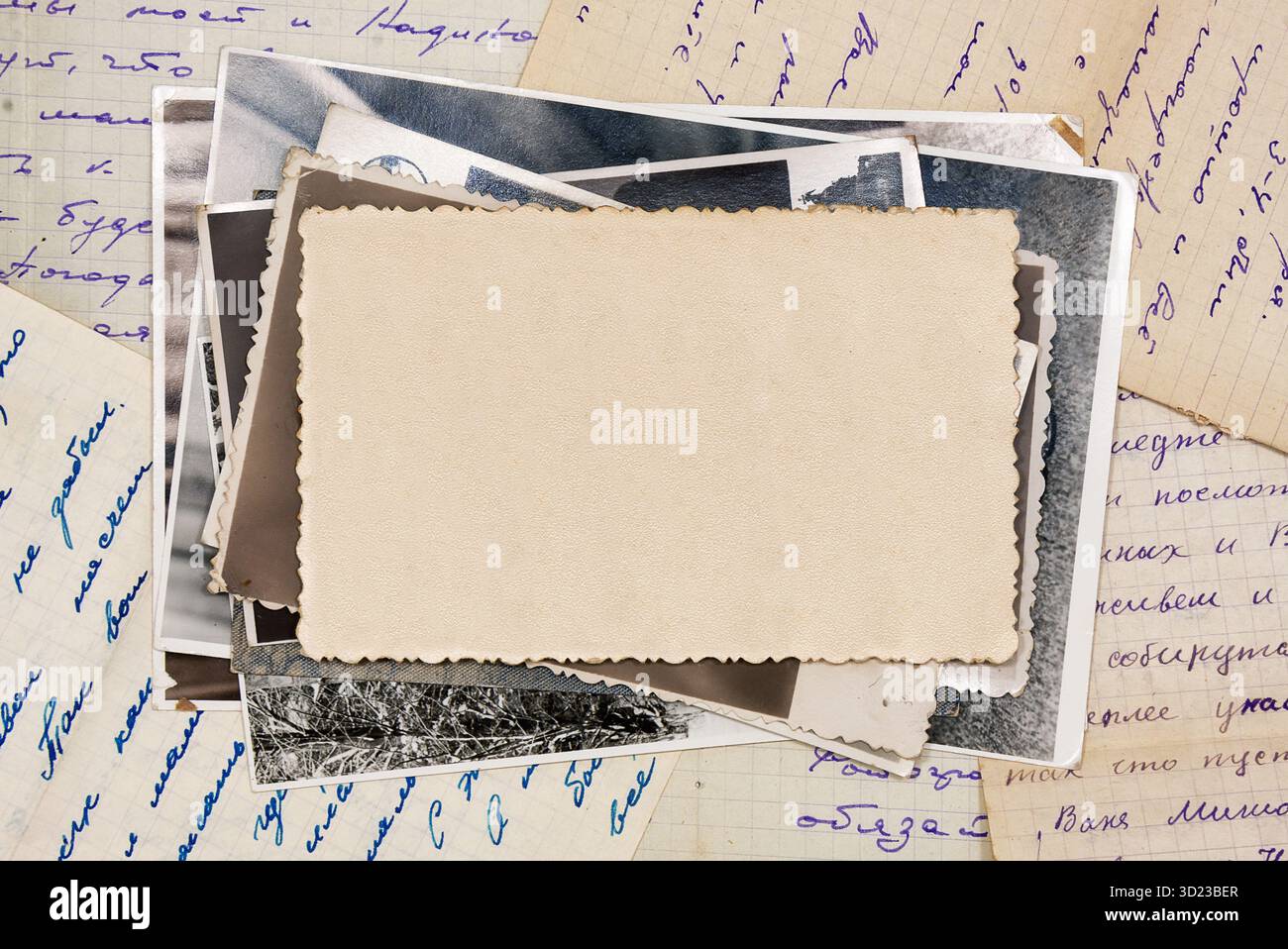 Stack old photos with blank copy space, lying on old letters. Abstract textured backdrop, postcard mockup. Stock Photo