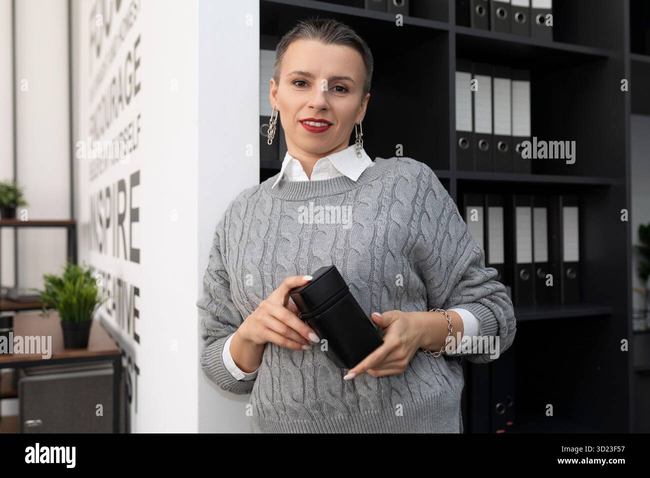 Business woman with a short haircut in the office with a stamp in her hands Stock Photo