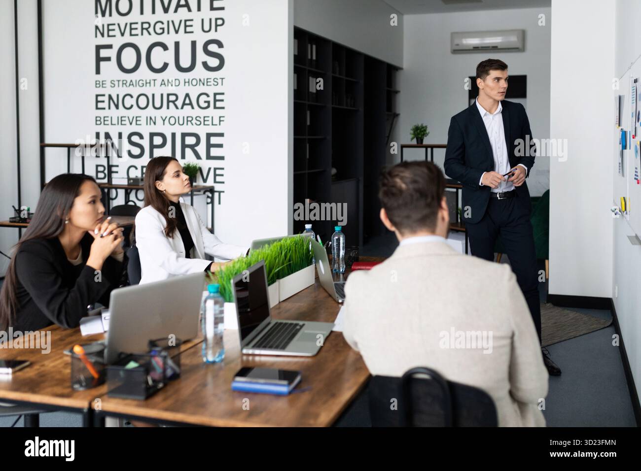 Marketing team. Group of young modern people in smart casual wear discussing something while working in the creative office Stock Photo