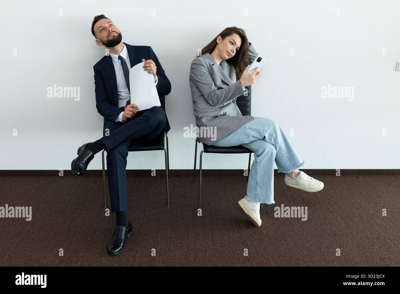 Office employees sit on chairs man and woman waiting for an interview Stock Photo