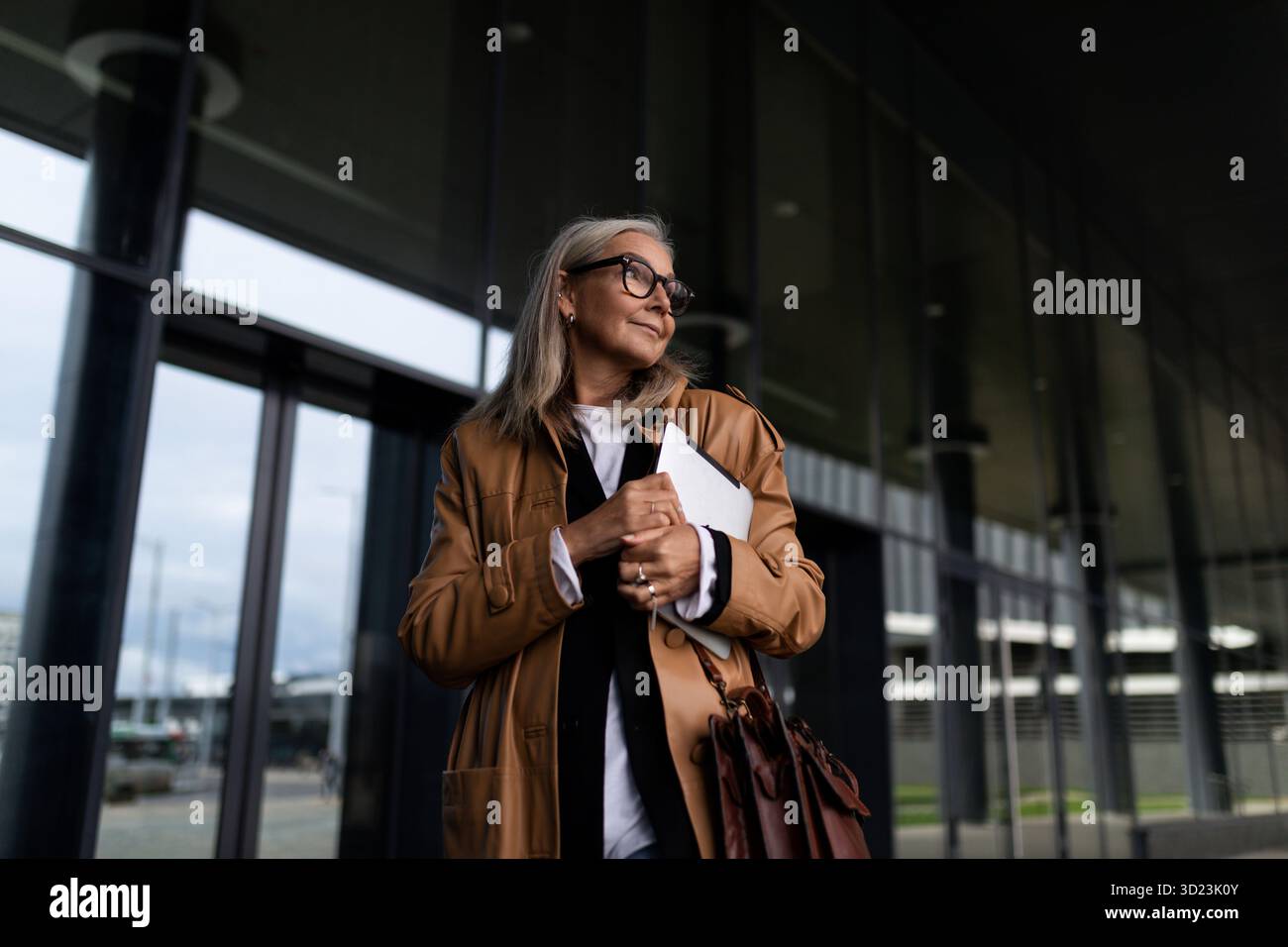 Half-length portrait of a strong elderly businesswoman at the entrance to the business center, strong and independent woman conc Stock Photo