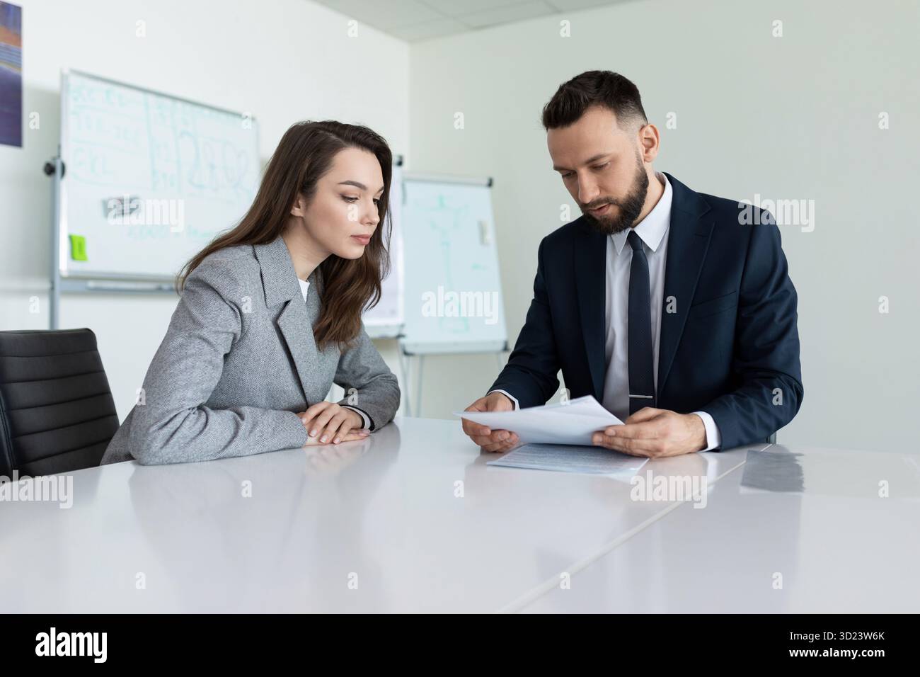 Farm workers studying a document sitting at a table in a meeting room Stock Photo