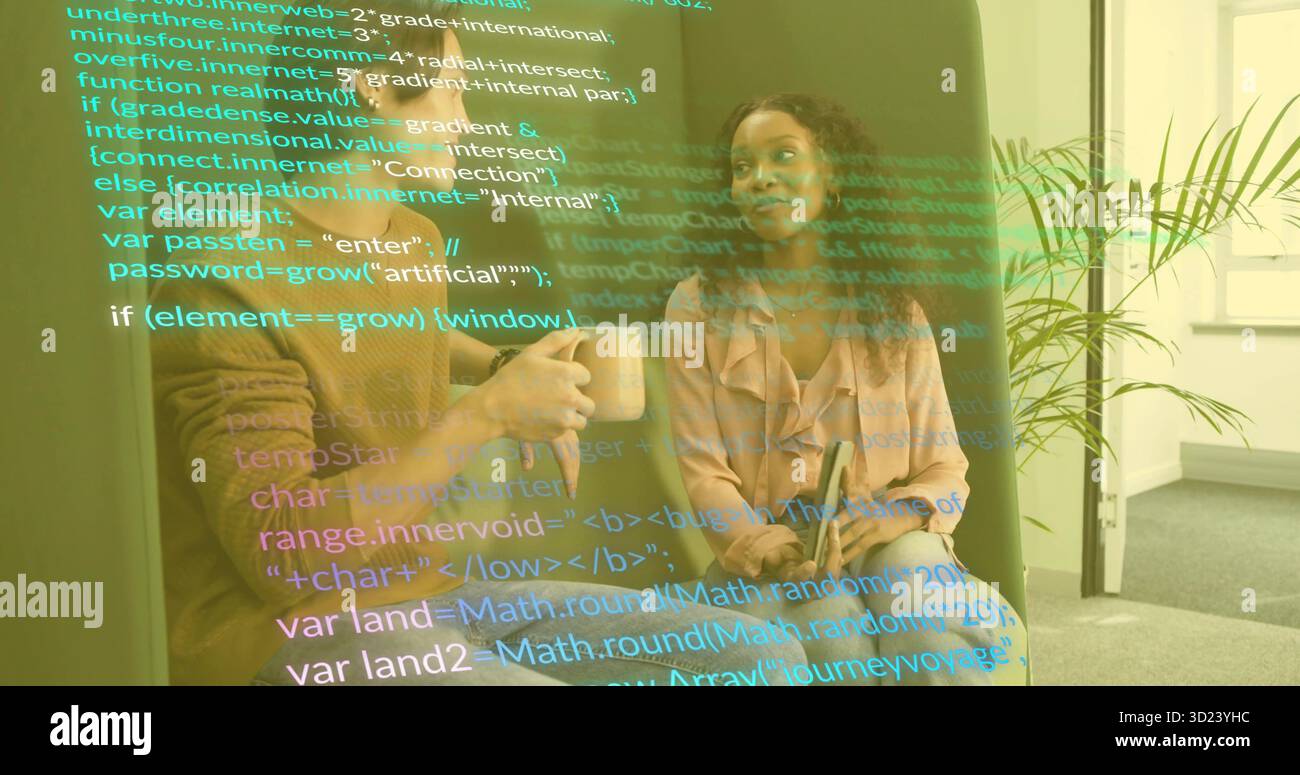Two software professionals discussing code overlay on sofa in office lounge, with mug and tablet Stock Photo