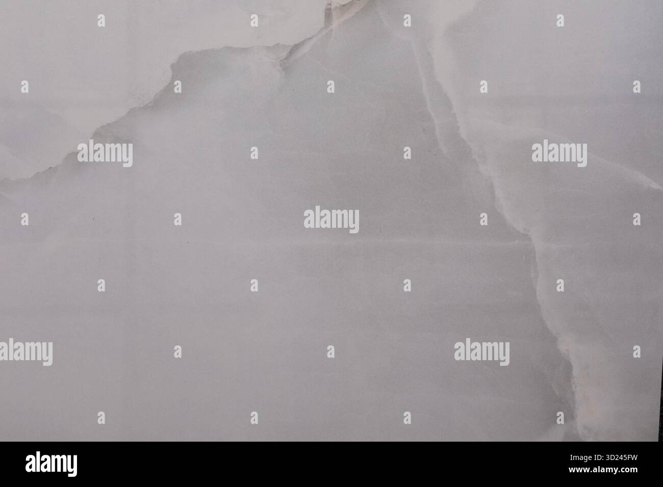 Torn white paper with soft texture and subtle shadows on a light background creating an abstract visual effect Stock Photo