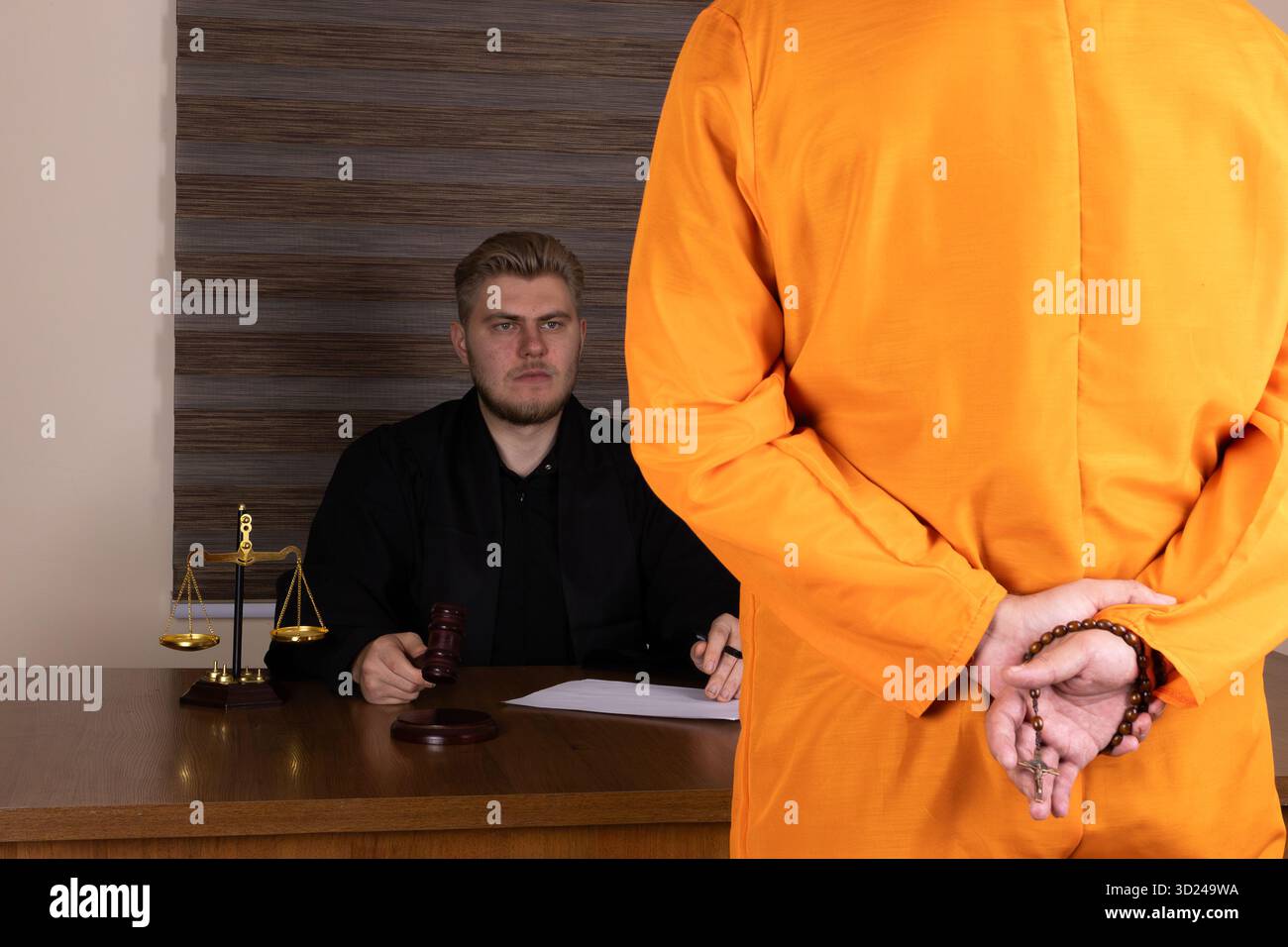 The judge presides over the court case while the defendant stands ...