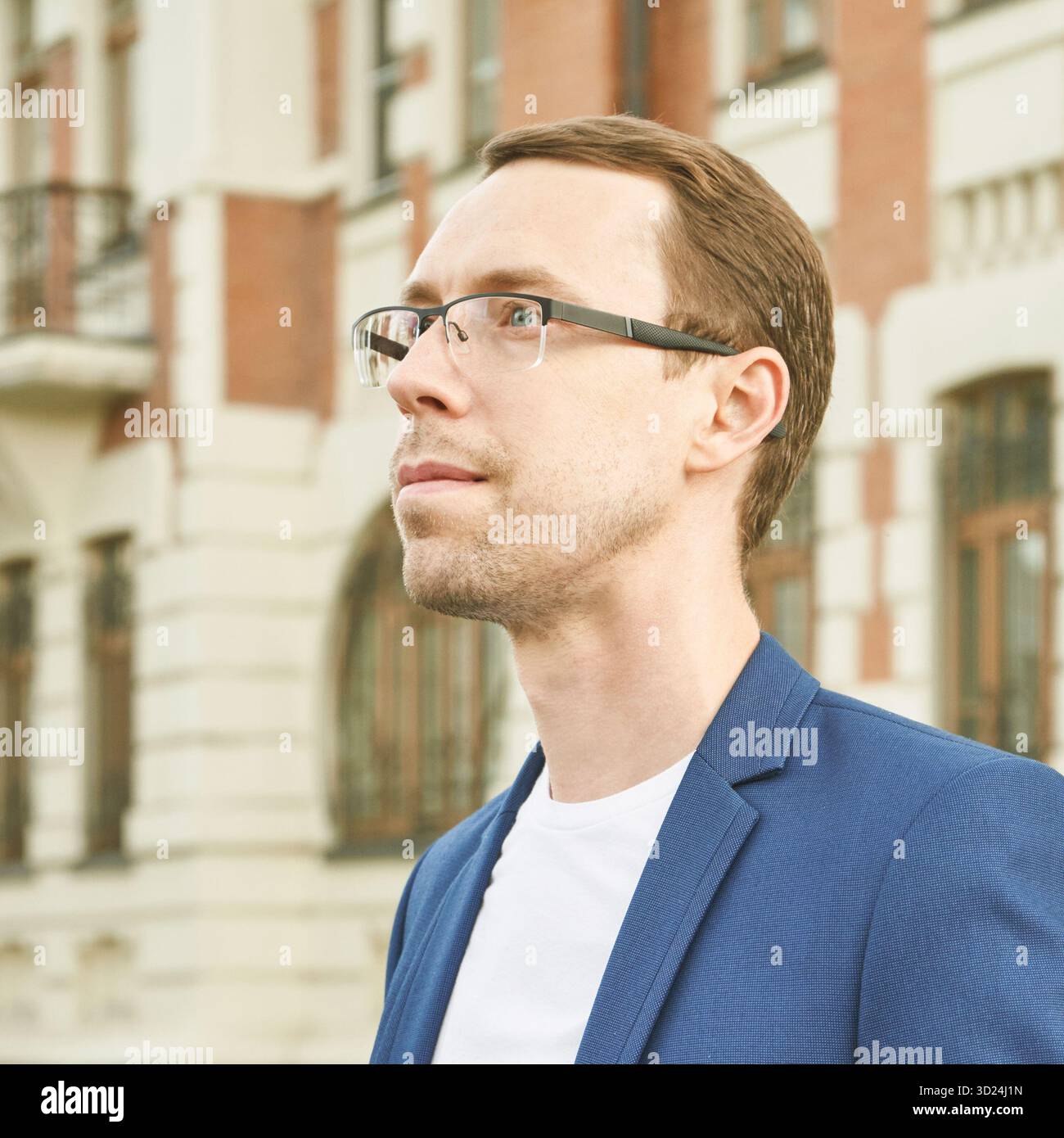 Caucasian male adult with glasses in blue blazer near historical building Stock Photo