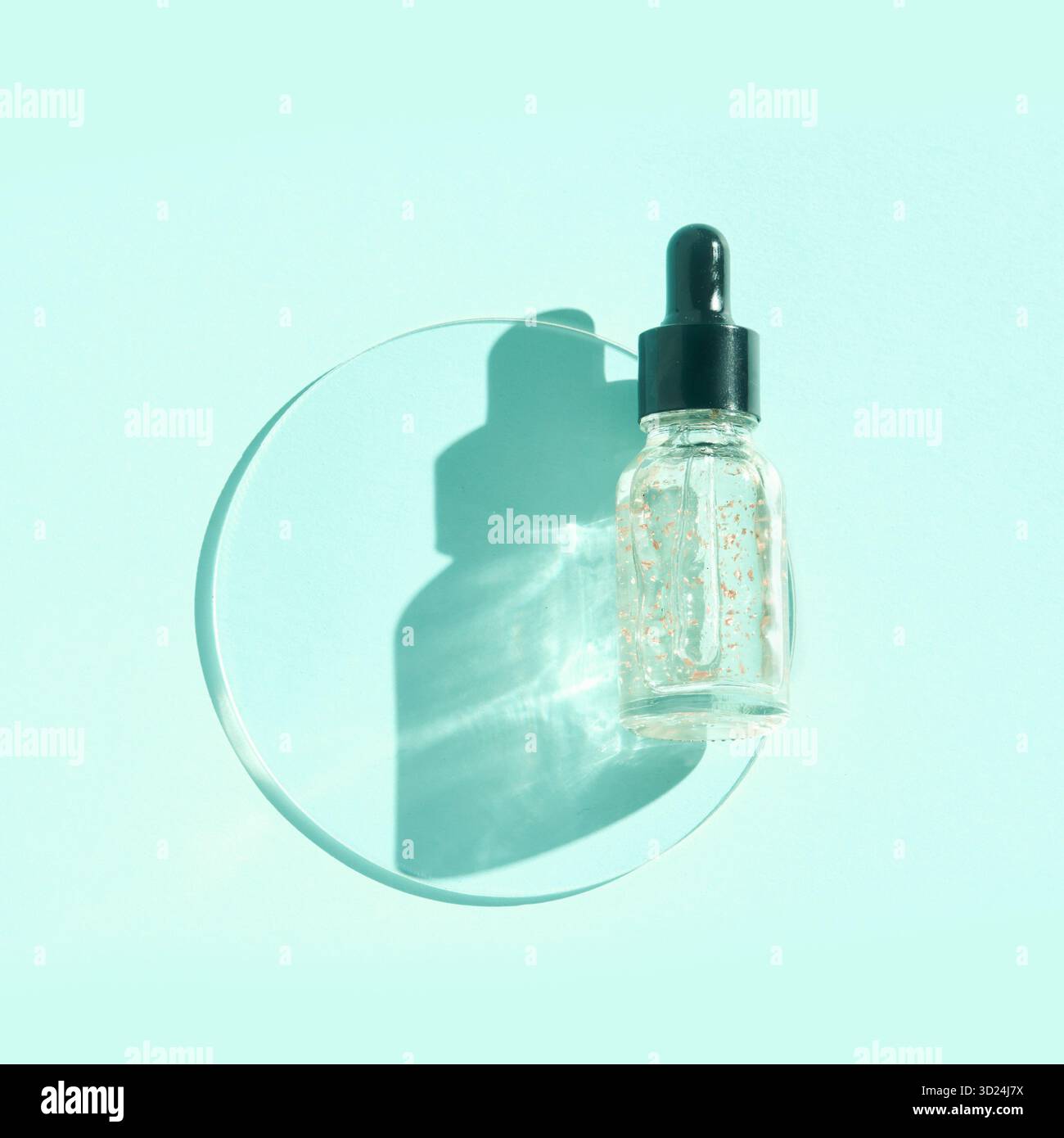 Transparent dropper bottle for serum or oil with black cap on pastel blue Stock Photo