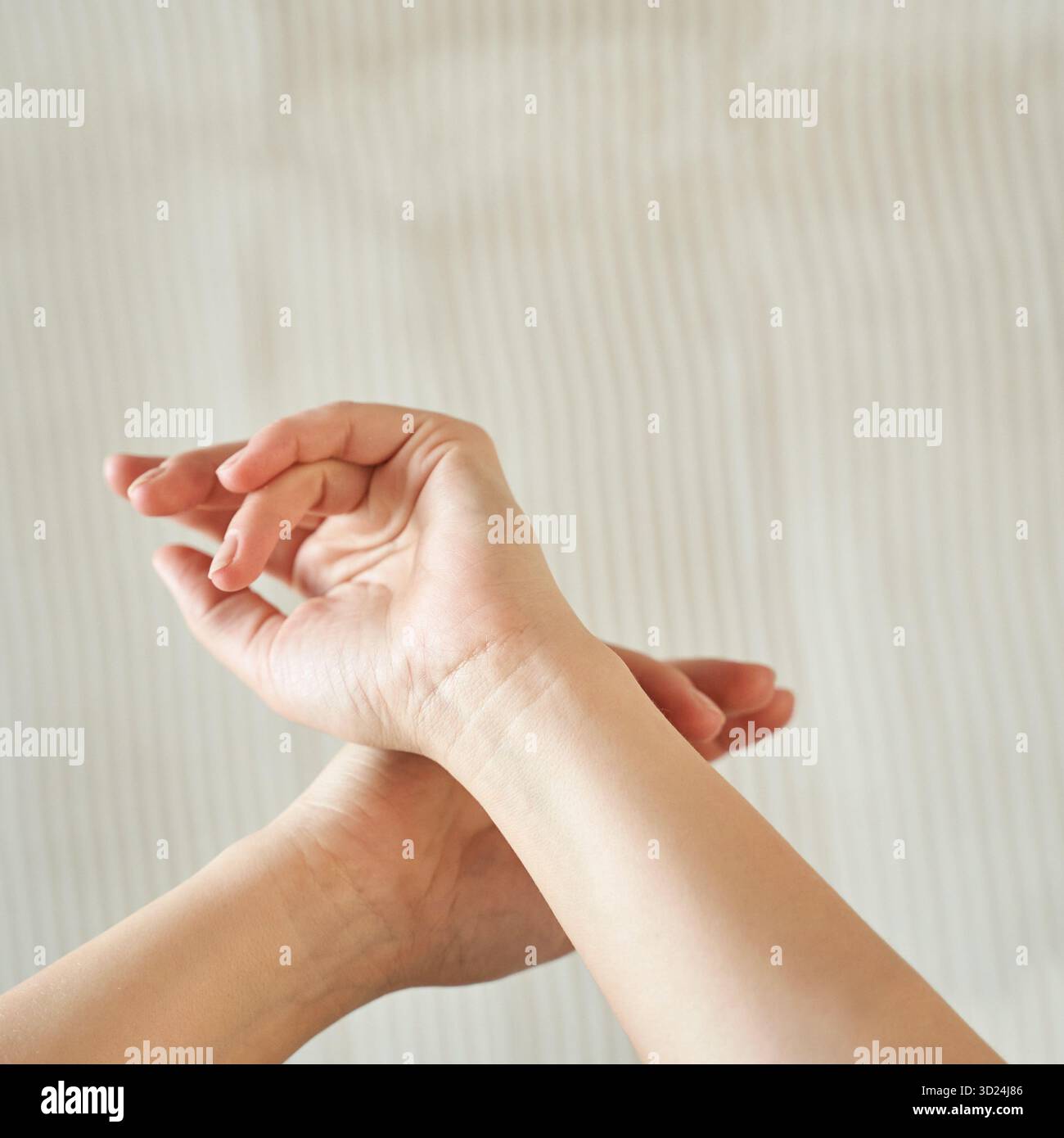 Close-up of hands with wrists crossed on neutral background displaying asian Stock Photo