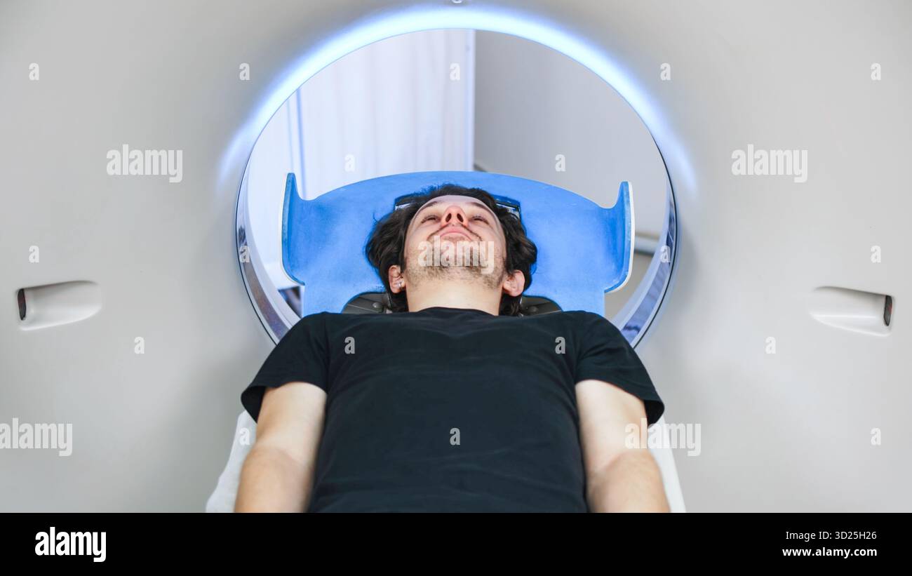Individual positioned on CT scanner table, ready for tomography ...