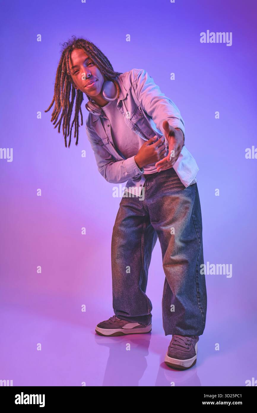 Young man with dreadlocks reaching out wearing Stock Photo