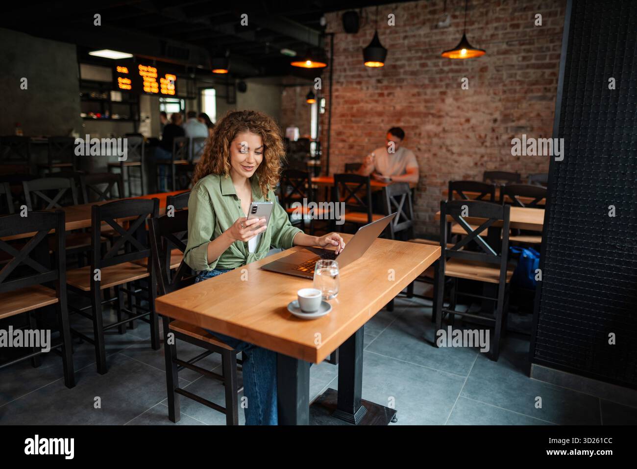 Freelancer is working at cafe using laptop and smartphone Stock Photo