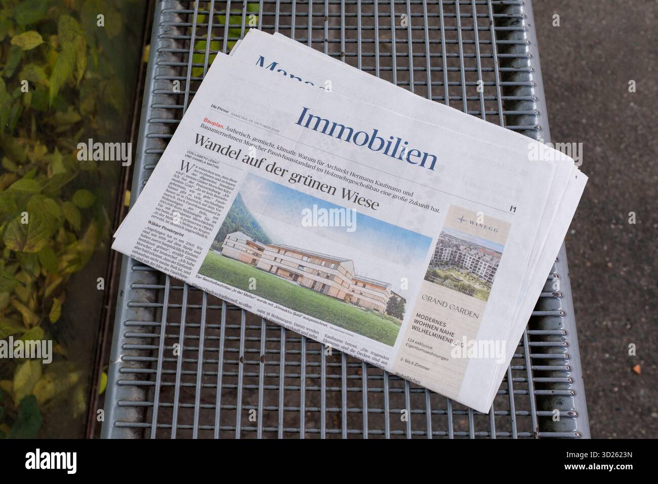 A copy of the property section of the newspaper Die Presse lies on a bench at a bus stop in Vienna. Symbolic image for house hunting and property sale Stock Photo