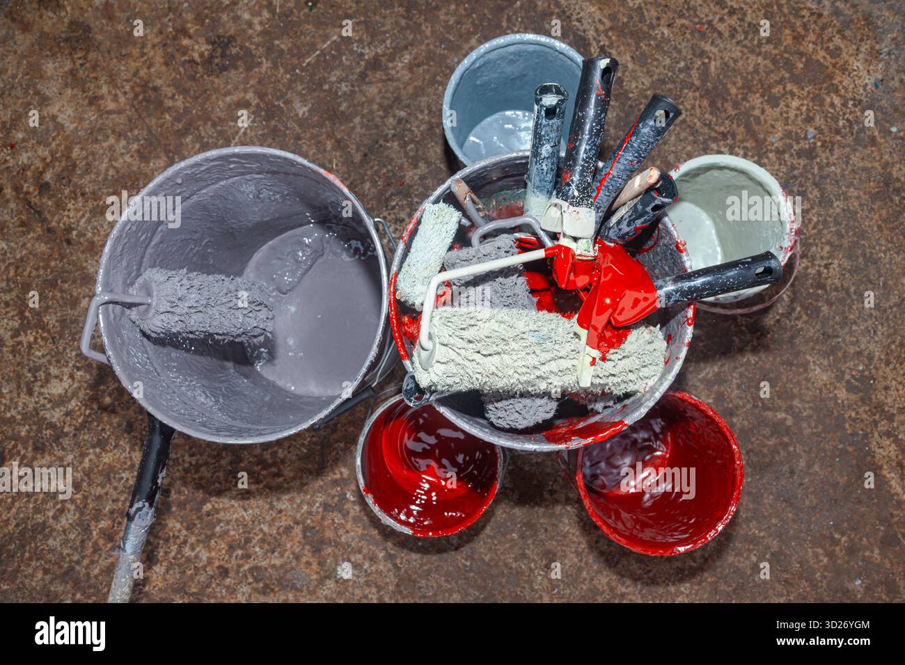 Empty paint buckets containing used rollers and brushes Stock Photo