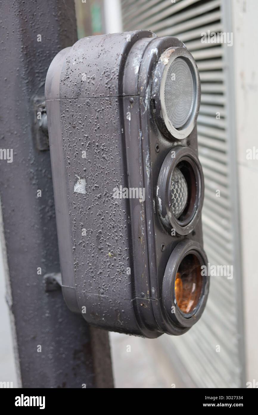 Weathered metal traffic light in France with lower yellow light on Stock Photo