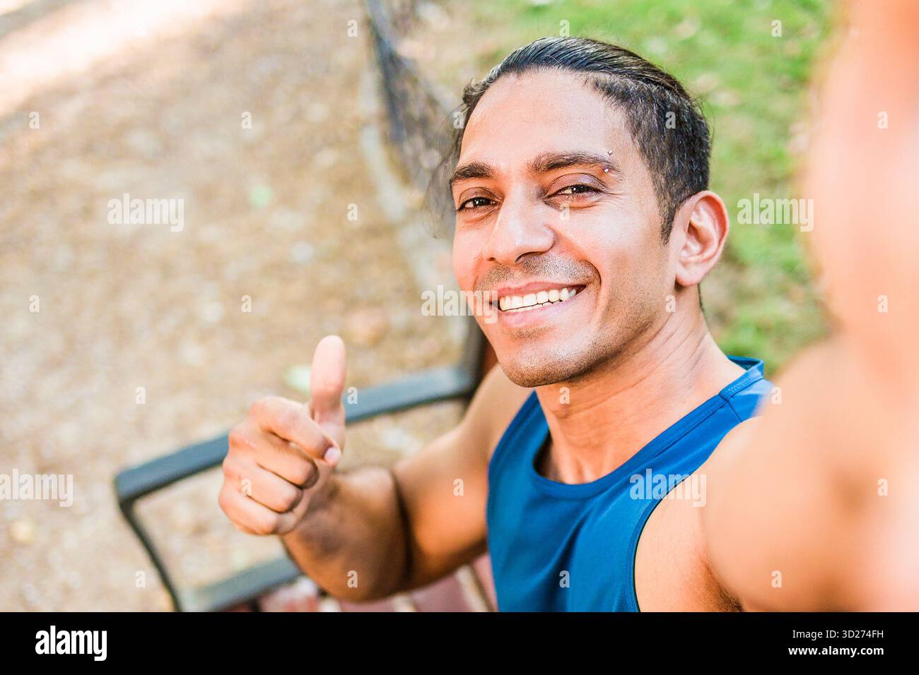 Disabled mid man latin athlete smiling giving thumbs up selfie Stock ...