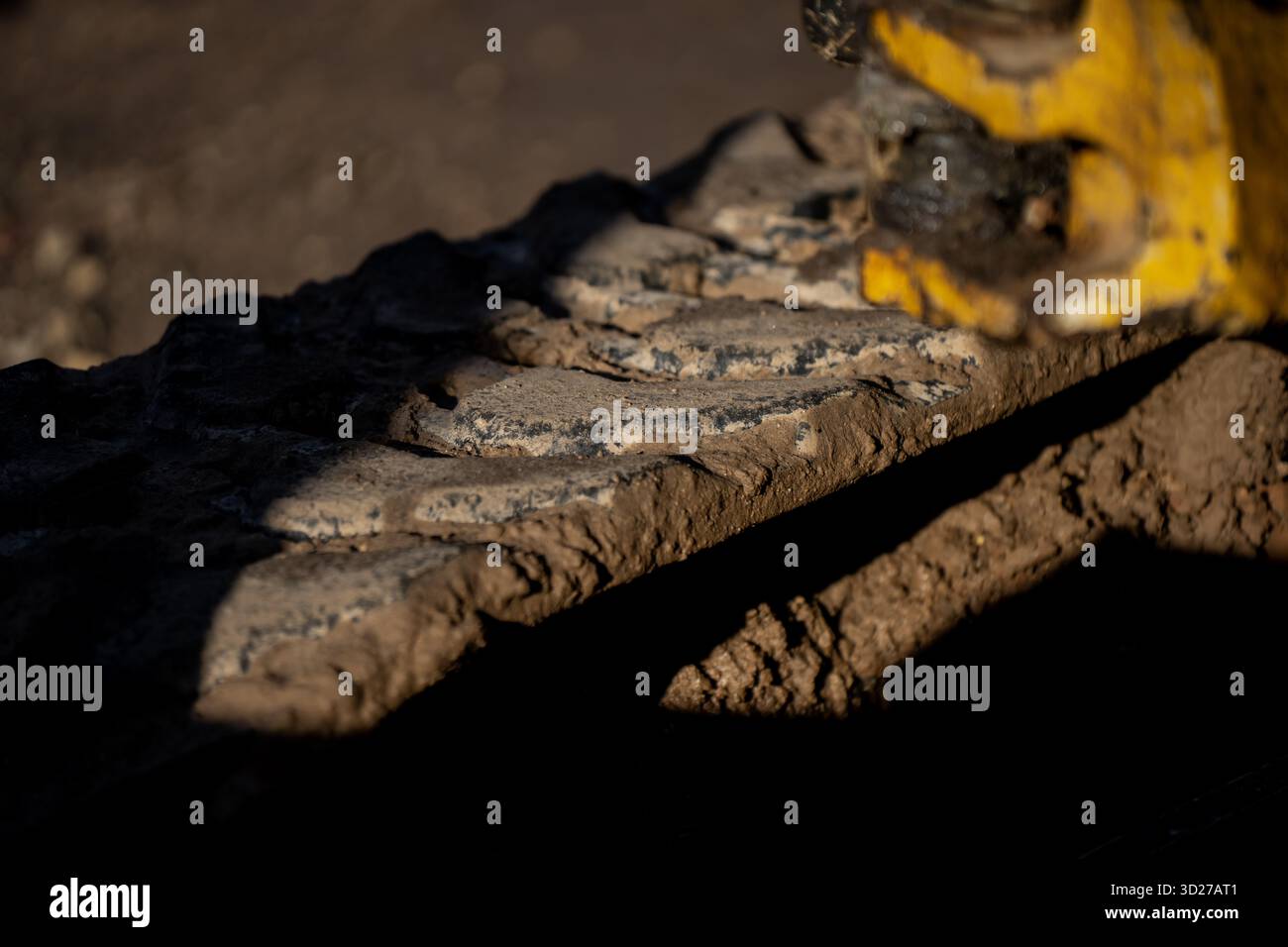 Heavy excavator steel track covered in dried mud showing traction plate ...