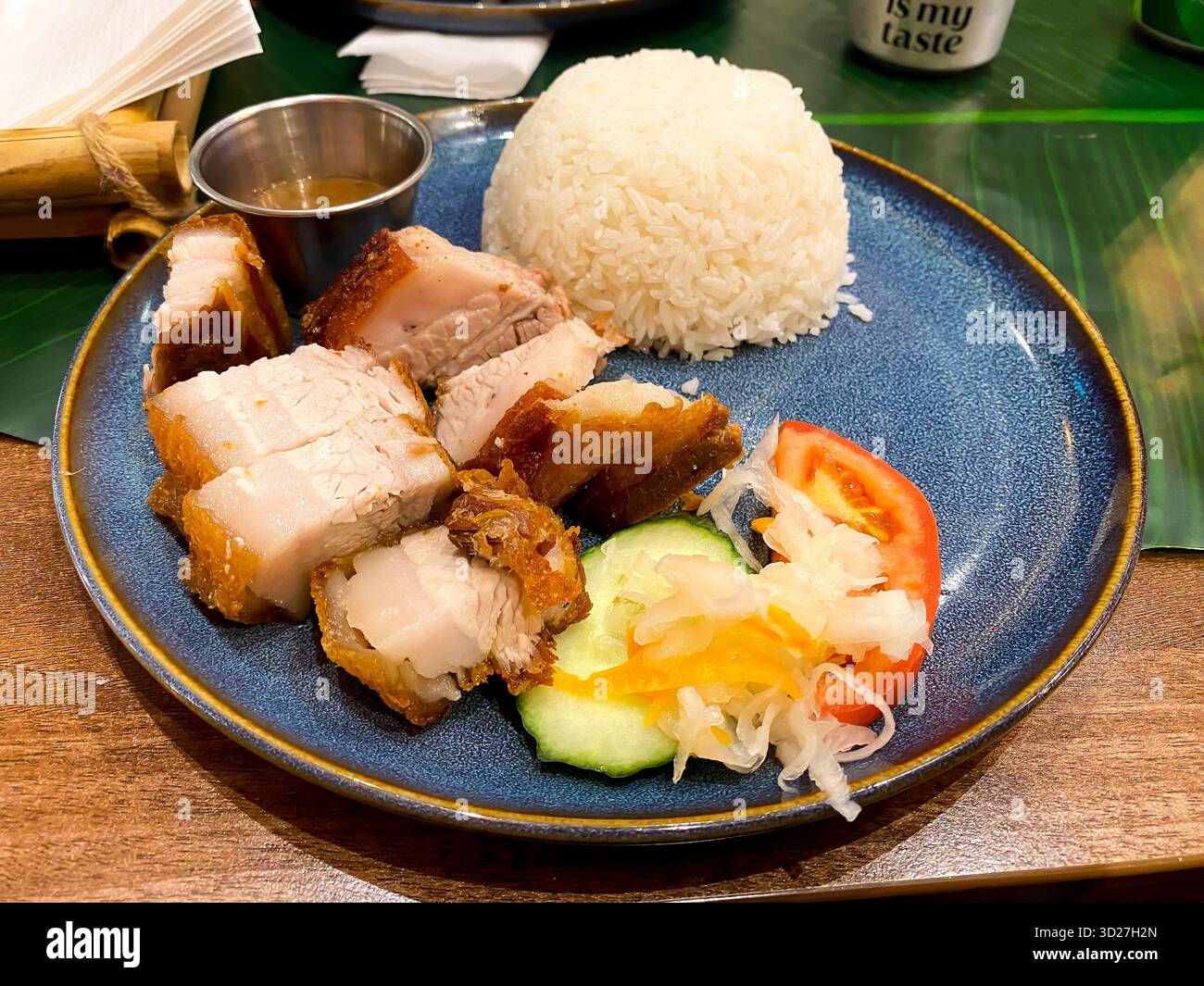 Lechon Kawali, a Filipino dish of fried belly pork served with rice and a salad garnish - Smartphone Captured Stock Image