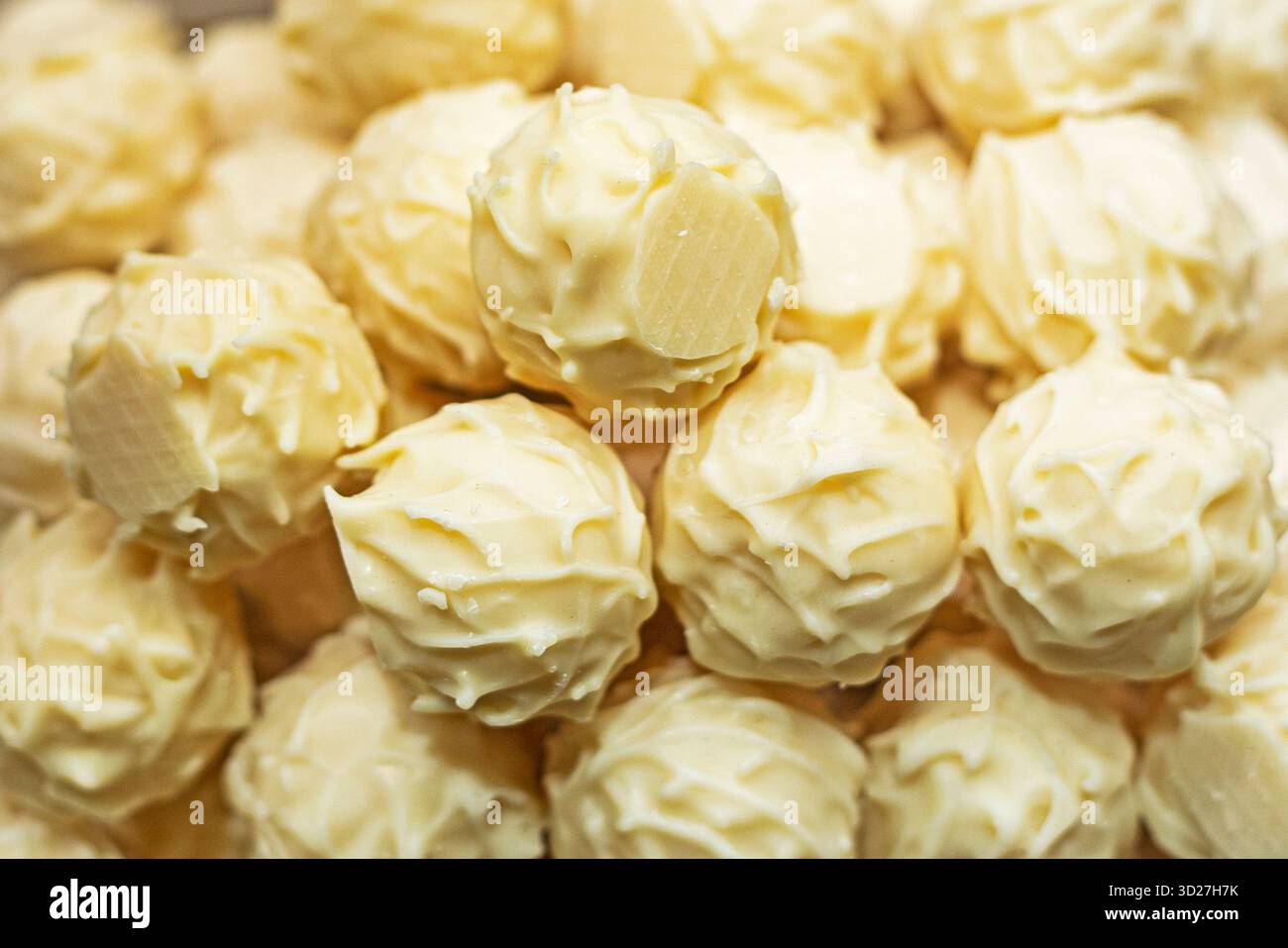 Round white chocolate candies on display Stock Photo - Alamy