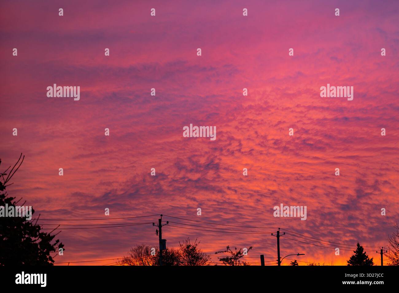 A vivid sunset sky filled with pink, orange, and purple clouds above a ...