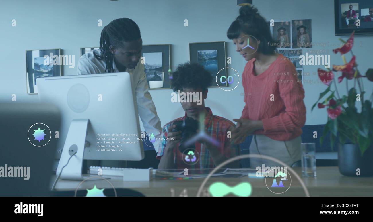 Collaborating three tech professionals coding with holographic icons at office desk, with tablet Stock Photo