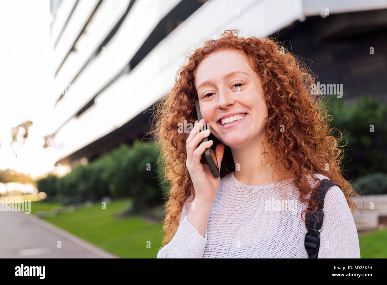 young woman smiling while talking on cell phone Stock Photo