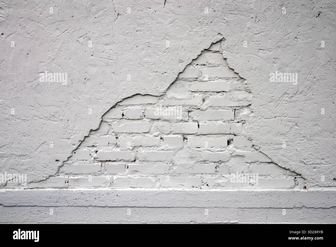 white painted brick wall with damaged plaster background Stock Photo