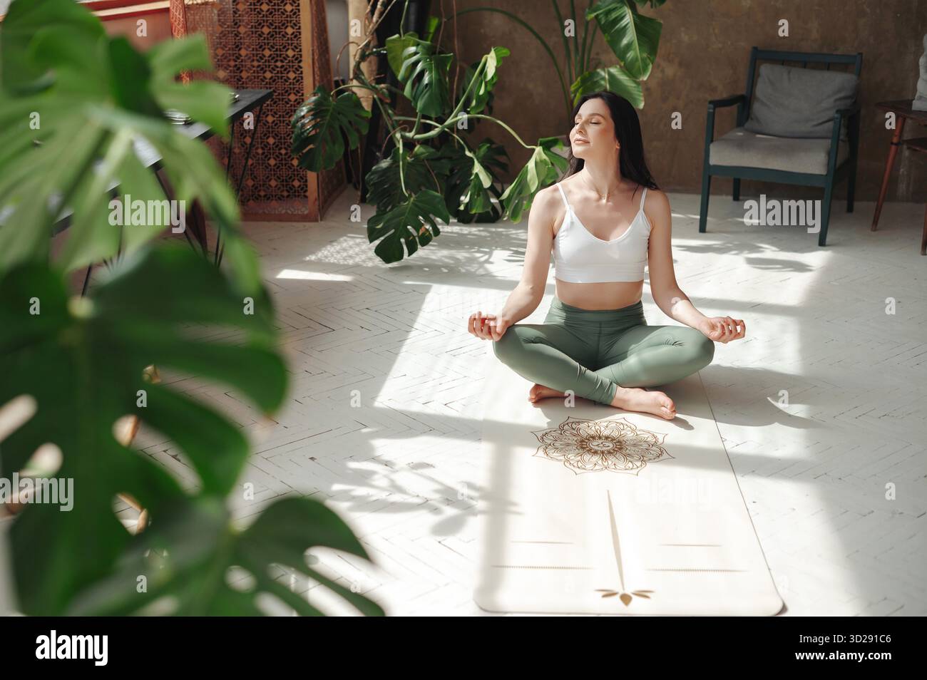 Charming lady performing padmasana exercise with closed eyes Stock Photo