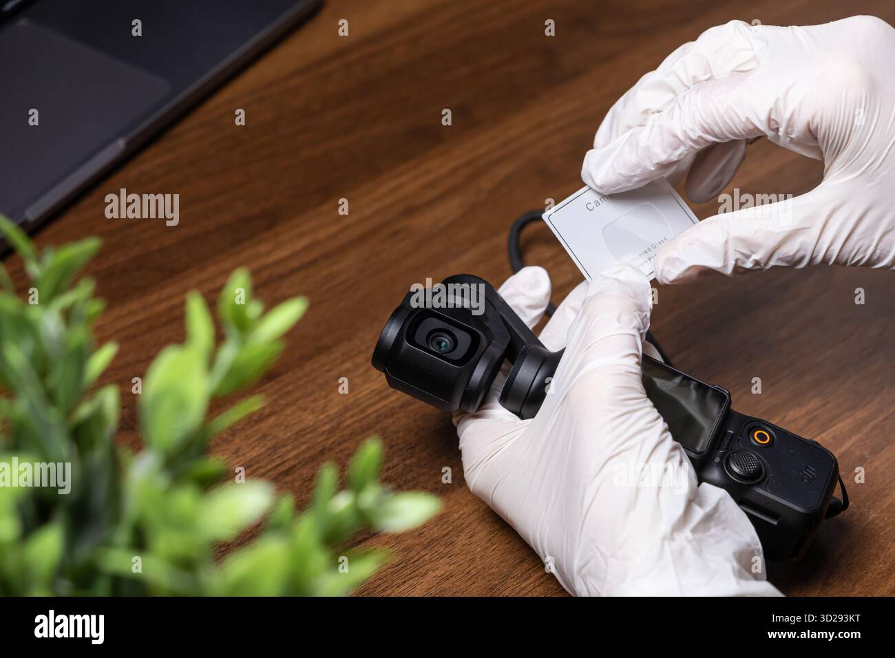 Poznan, Poland - October 16, 2025: Gloved hands meticulously applying transparent protective film to the DJI Osmo Pocket screen, ensuring precise equi Stock Photo