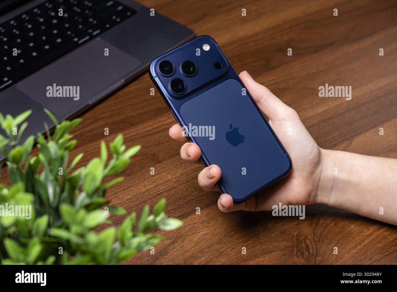 Poznan, Poland - October 16, 2025: iPhone 17 Pro, a blue smartphone with triple camera, is held by hand, representing modern digital lifestyle Stock Photo