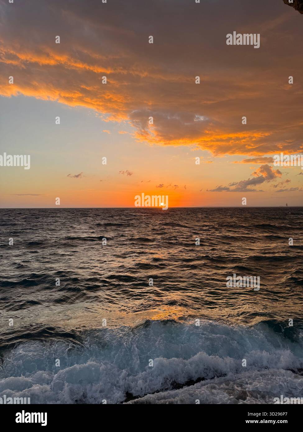That moment when the clouds steal the show and the sea reminds you just how powerful nature is. The final, spectacular curtain call before the night - Smartphone Captured Stock Image