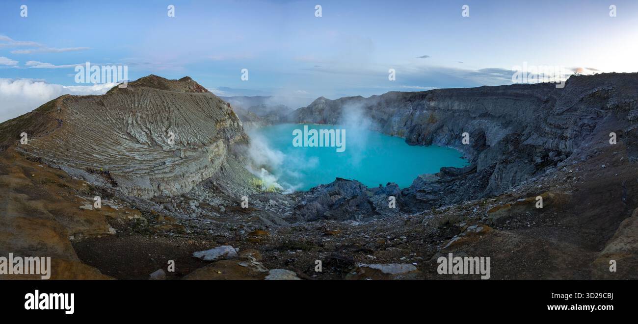 View of the electric blue crater lake nestled within the rugged, smoky ...