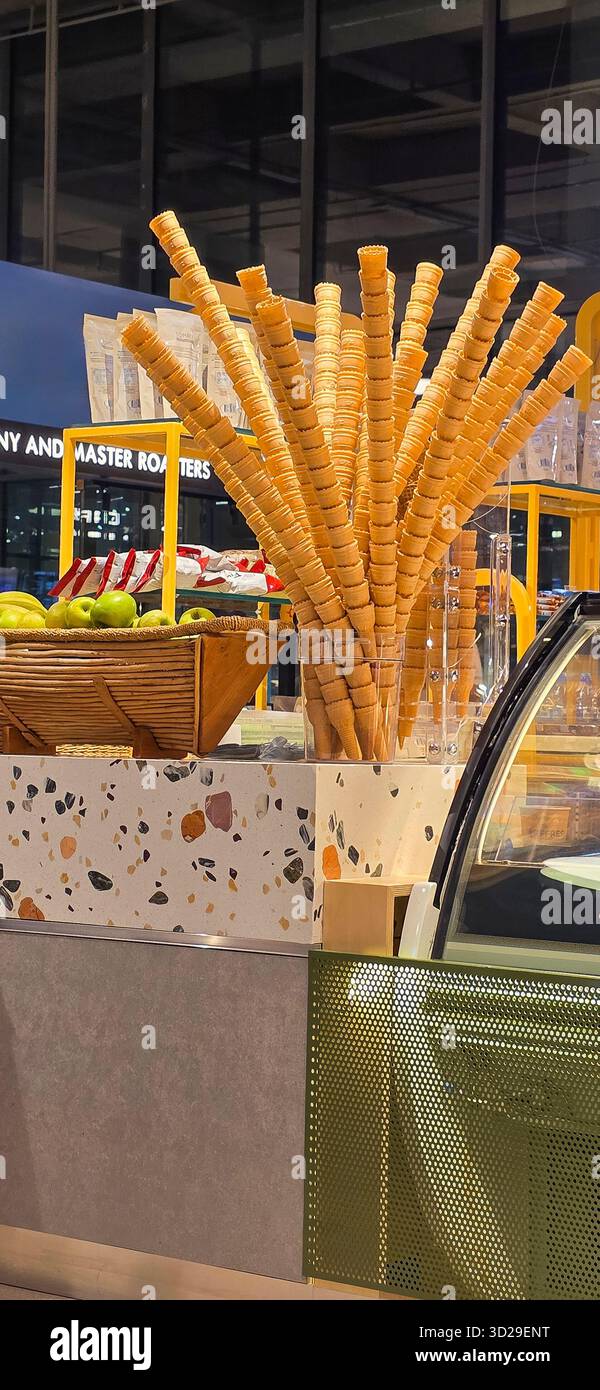Doloman, Turkey - April 25, 2025: Ice cream cone display stands next to fresh apples in a contemporary dessert shop. - Smartphone Captured Stock Image